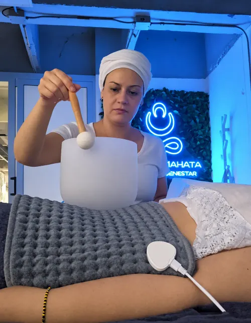 Cuenco de cuarzo sobre el vientre durante el baño sonoro de la terapia de útero en Envigado