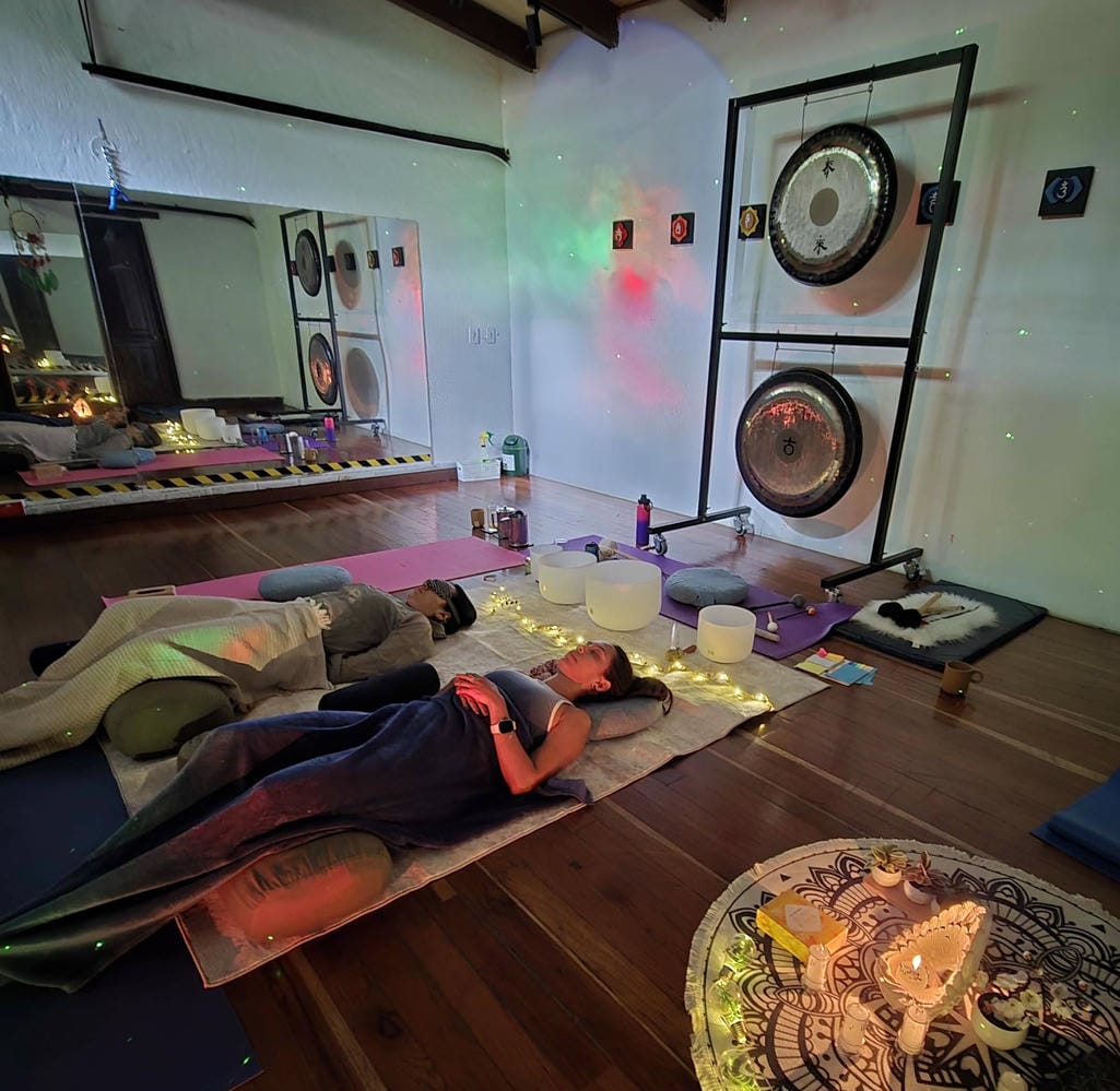 Participantes en relajación profunda durante una sesión de sonido terapéutico en Medellín